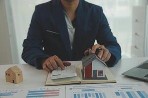 Businessmen holding pens, signing home titles with insurance, care about real estate services and the idea of real estate agents offering interest in installments to their customers. photo