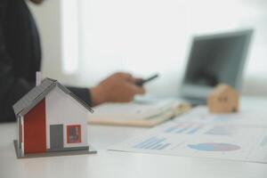 Businessmen holding pens, signing home titles with insurance, care about real estate services and the idea of real estate agents offering interest in installments to their customers. photo