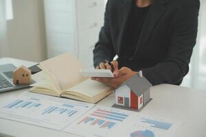 Businessmen holding pens, signing home titles with insurance, care about real estate services and the idea of real estate agents offering interest in installments to their customers. photo