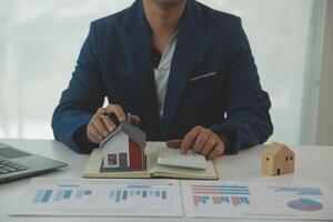 Businessmen holding pens, signing home titles with insurance, care about real estate services and the idea of real estate agents offering interest in installments to their customers. photo