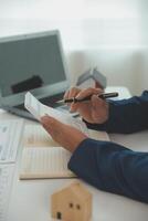 Businessmen holding pens, signing home titles with insurance, care about real estate services and the idea of real estate agents offering interest in installments to their customers. photo