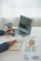 Businessmen holding pens, signing home titles with insurance, care about real estate services and the idea of real estate agents offering interest in installments to their customers. photo