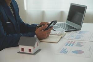 Businessmen holding pens, signing home titles with insurance, care about real estate services and the idea of real estate agents offering interest in installments to their customers. photo