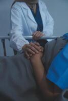 Cropped shot of a female nurse hold her senior patient's hand. Giving Support. Doctor helping old patient with Alzheimer's disease. Female carer holding hands of senior man photo