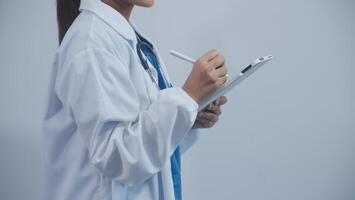 Woman doctor using tablet computer while standing straight in hospital photo