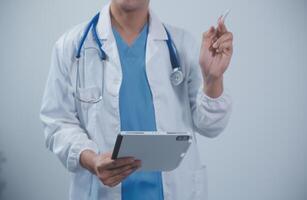 maduro masculino médico con tableta ordenador personal es dando presentación. borroso antecedentes adentro. foto