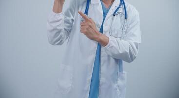 Mature male doctor with tablet pc is giving presentation. Blurred background indoors. photo