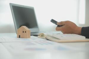 Businessmen holding pens, signing home titles with insurance, care about real estate services and the idea of real estate agents offering interest in installments to their customers. photo