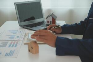 Businessmen holding pens, signing home titles with insurance, care about real estate services and the idea of real estate agents offering interest in installments to their customers. photo