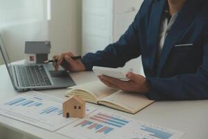 Businessmen holding pens, signing home titles with insurance, care about real estate services and the idea of real estate agents offering interest in installments to their customers. photo