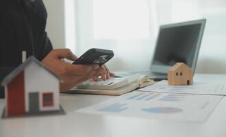 Businessmen holding pens, signing home titles with insurance, care about real estate services and the idea of real estate agents offering interest in installments to their customers. photo