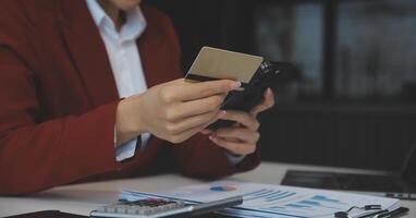 mano participación crédito tarjeta y utilizando ordenador portátil. mujer de negocios o empresario trabajando desde hogar. en línea compras, comercio electrónico, Internet bancario, gasto dinero, trabajo desde hogar concepto foto