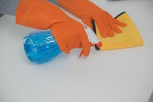 mujer limpieza mesa utilizando trapo y difusor a hogar. foto