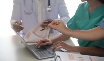 médico equipo reunión alrededor mesa en moderno hospital foto