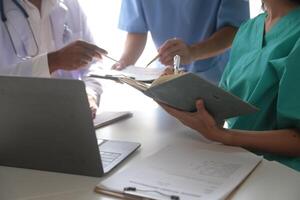 Medical Team Meeting Around Table In Modern Hospital photo