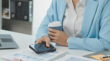 Charming Young asian businesswoman sitting on laptop computer in the office, making report calculating balance Internal Revenue Service checking document. photo