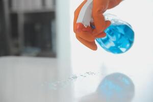 Woman cleaning table using rag and diffuser at home. photo