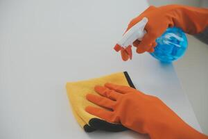 Woman cleaning table using rag and diffuser at home. photo