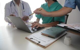 médico equipo reunión alrededor mesa en moderno hospital foto