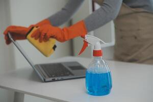 Woman cleaning table using rag and diffuser at home. photo