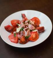 Tomato and tuna salad, with onion. Gourmet dish with quality tomatoes. photo