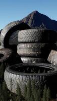 concept of environmental pollution with big old tires in mountain forest video