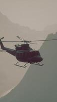 A helicopter flying over a mountain with a sky background video