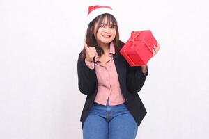 hermosa asiático niña en traje alegre sonrisa con Papa Noel claus sombrero posando con Navidad regalo caja regalo y levantamiento caja y bueno en blanco antecedentes para promoción, publicidad, bandera, cartelera foto