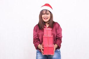 beautiful young southeast asian girl happy carrying 3 boxes gifts in christmas wearing santa claus hat modern red shirt outfit holding all white background for promotion and advertising photo