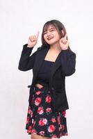 Beautiful Asian Indonesian girl in a casual professional office skirt, happy, right hand pointing upwards on a white background for promotion, advertising, banner photo