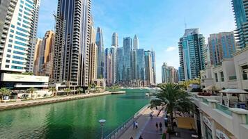 Dubai - - vereinigt arabisch Emirate 01.05.2024 modern Wolkenkratzer neben städtisch Dubai Yachthafen, Panorama- Aussicht von ein lebhaft städtisch Kanal flankiert durch hoch aufragend Wolkenkratzer und geschäftig Bürgersteige im das Herz von video