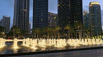 Urban Fountain with Skyscrapers at Twilight, A serene twilight scene of an urban fountain surrounded by towering skyscrapers and palm trees. video