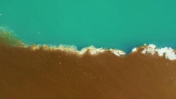 Aerial drone view of polluted river. The aftermath of excessive phosphate release to the river. Turquoise and brown colors. Environmental disaster caused by humans. Ecological concern. video