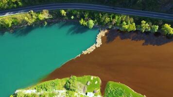 Aerial drone view of polluted river. The aftermath of excessive phosphate release to the river. Turquoise and brown colors. Environmental disaster caused by humans. Ecological concern. video