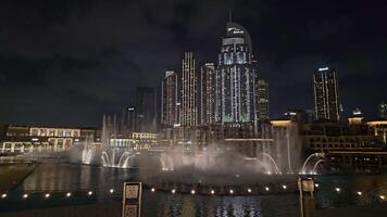 Dubai - - vereinigt arabisch Emirate 01.05.2024 Zeitraffer spektakulär Brunnen Show im Innenstadt Dubai. ein faszinierend Brunnen Show Beleuchtung oben das Nacht, einstellen gegen das Hintergrund von beleuchtet Wolkenkratzer im video