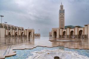 casa blanca, Marruecos -marzo 25, 2024-personas visitar el famoso hassan segundo mezquita durante un lluvioso día foto