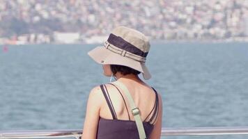 jovem turista mulher dentro chapéu em navio assistindo a oceano video