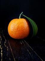 Two ripe juicy tangerines on a black background. photo