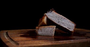 Roasted pork entrecote cut into pieces on a wooden cutting board. Grilled pork entrecote. Pork steak. photo