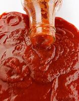 tomate salsa . vaso botella con salsa de tomate. salsa de tomate es torrencial fuera de el cuello de un vaso botella. foto