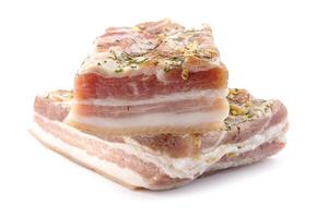 Appetizing salty lard with layers of meat with garlic and herbs. Two pieces of salted lard isolated on a white background. photo
