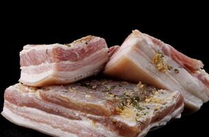 Appetizing salty lard with layers of meat with garlic and herbs. Delicious lard on a wooden cutting board. photo