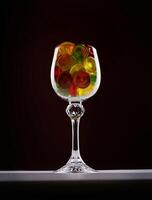 Glass goblet full of beautiful multi-colored candies. Multi-colored candies in a glass goblet. photo