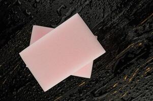 Melamine sponge on a black wet background. Beautiful drops of water around a melamine sponge. photo