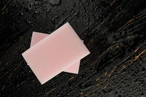 Melamine sponge on a black wet background. Beautiful drops of water around a melamine sponge. photo