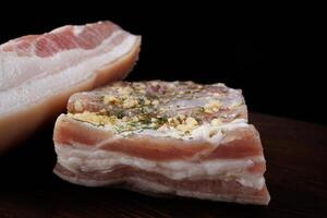 Appetizing salty lard with layers of meat. Salted lard with garlic and herbs. photo