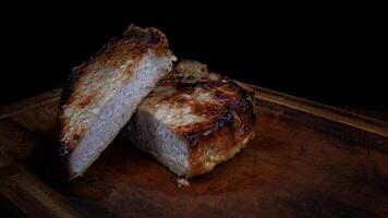 Roasted pork entrecote cut into pieces on a wooden cutting board. Grilled pork entrecote. Pork steak. photo
