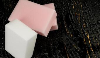 Melamine sponge on a black wet background. Beautiful drops of water around a melamine sponge. photo