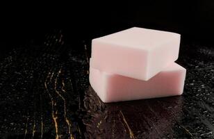 Melamine sponge on a black wet background. Beautiful drops of water around a melamine sponge. photo