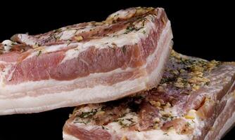 Appetizing salty lard with layers of meat. Salted lard with garlic and herbs. photo